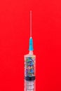 A classic disposable syringe filled with symbolic hearts. Love concept. Background with copy space. Red backdrop