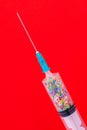 A classic disposable syringe filled with symbolic hearts. Love concept. Background with copy space. Red backdrop