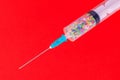 A classic disposable syringe filled with symbolic hearts. Love concept. Background with copy space. Red backdrop