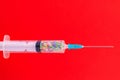 A classic disposable syringe filled with symbolic hearts. Love concept. Background with copy space. Red backdrop
