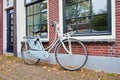Classic Dutch bicycle parked against brick house in autumn, Gouda, Netherlands