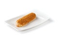 Classic eclair on a white plate on an isolated white background