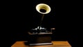 Classic Edison Phonograph on a wooden table in a dark studio. Retro vintage machine to reproduce sound making listening