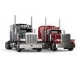 Classic eighteen wheeler trucks in metallic gray and red colors - side by side