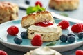 Classic English scones with clotted cream, strawberries jam and other fruit Royalty Free Stock Photo