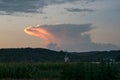 An anvil of a distant thunderstorm in Romania is colored by the light of the setting sun