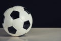 Classic football ball, black and white pattern, isolated on the table with copy space. Real, traditional soccer ball symbol