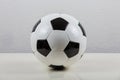 Classic football ball on the table, black and white typical hexagon pattern, isolated on grey background. Real, traditional