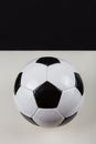 Classic football ball, typical hexagon pattern, isolated on grey table with black copy space background above. Real, traditional