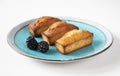 Classic French holiday pastries - financier cake dessert on a beautiful azure plate with fresh blackberries - side view with copy