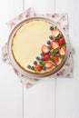Classic Freshly New York Cheesecake with fresh berries and mint closeup on the plate. Vertical top view Royalty Free Stock Photo