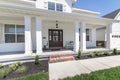 Classic front porch of a house with white siding exterior