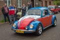 Classic funny colorful Volkswagen Beetle driving at a car show