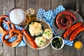 Classic German Oktoberfest meal table scene over a dark wood background