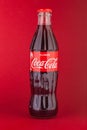 Classic glass Coca-Cola bottle with a volume of 0.33 liters isolated on a red background. Moscow, August, 2020