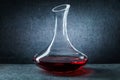 Classic glass decanter with red wine on black background