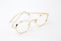 Classic gold round glasses on white background.