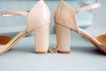 Classic gold wedding rings and beige patent leather bride shoes, close-up. Wedding rings near heels Royalty Free Stock Photo