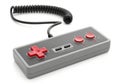 Classic gray video game controller with red buttons and coiled cable on white background Royalty Free Stock Photo
