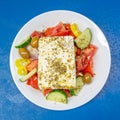 Classic Greek salad plate with original feta cheese, olives, green pepper, tomatoes, onions and cucumber slices Royalty Free Stock Photo