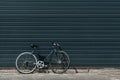 Classic hipster bicycle standing near black wall outdoors