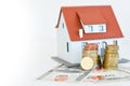Classic home model with pile of coins isolated Royalty Free Stock Photo