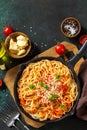 Classic homemade italian spaghetti pasta with tomato sauce, cheese parmesan and basil on dark stone table. Top view, flat lay