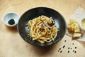 Classic, homemade pasta with black truffle, parmesan and mushrooms in black bowl. Traditional italian cuisine