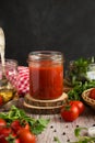 Classic homemade tomato sauce for pasta and pizza in a glass jar on a board. Composition with herbs, spices and tomatoes. Royalty Free Stock Photo