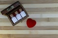 Classic homeopathy for for healthy heart - Wooden box with homeopath medicine glass bottles of pills and heart on wood background