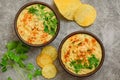 Classic hummus with parsley close-up, chips, top view