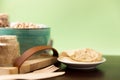 Classic hummus on a small plate on wooden table. Green Background.