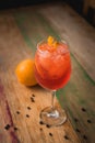 Classic Italian Aperol Spritz cocktail, with lemon in the background