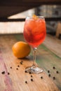 Classic Italian Aperol Spritz cocktail, with lemon in the background
