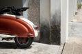 Classic Italian scooter parked by a battered wall