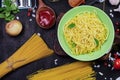 Classic Italian spaghetti pasta in a mouthwatering green dish. With ketchup and basil, garlic, onions, spaghetti, tomatoes, wooden Royalty Free Stock Photo