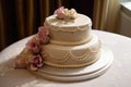 classic ivory ring cake with delicate pink flowers and pearl accents