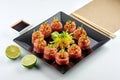 Classic Japanese food - Philadelphia sushi roll with spicy salmon and tuna served in a black plate on a white plate. Close up, Royalty Free Stock Photo