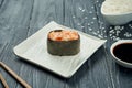 Classic japanese sushi rolls - gunkan with salmon and spicy white sauce on a white ceramic plate on a black wooden background. Royalty Free Stock Photo