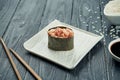 Classic japanese sushi rolls - gunkan with tuna and spicy white sauce on a white ceramic plate on a black wooden background. Close Royalty Free Stock Photo