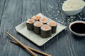 Classic japanese sushi rolls - maki rolls with salmon on a white, ceramic plate on a black wooden background Royalty Free Stock Photo