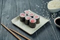 Classic japanese sushi rolls - maki rolls with tuna on a white, ceramic plate on a black wooden background Royalty Free Stock Photo