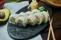 Classic japanese sushi rolls with soft crab avocado. California roll on a black plate with chopsticks. Japanese cuisine. Healthy