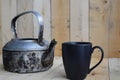 Classic kettle with black coffee cup on wood board