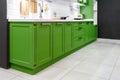 Classic kitchen interior with green trim. Kitchen acrylic countertop with built-in sink Royalty Free Stock Photo