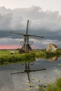 Classic landscape image of Holland with windmill and beautiful clouds at sunset Royalty Free Stock Photo