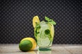 Classic lemonade in a skull-shaped glass at a marble board with pieces of ice on a spotted background. Halloween zombie