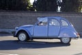 Classic light blue Citroen rides the highway. The driver is a man. Side view