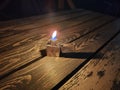 A classic lighter standing on a table in the dark. Royalty Free Stock Photo