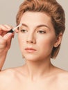 Classic makeup in nude color - styling eyebrows with gel. Close-up shot in studio